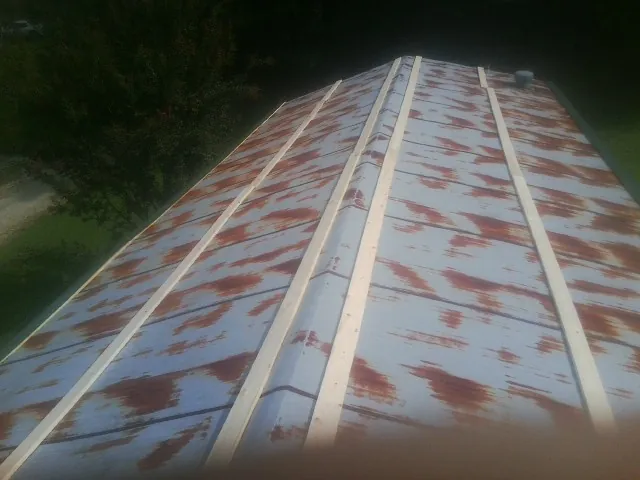 Rusted metal roof panels with new wood purlins before replacement — Storm Damage Roof Repair in Vonore by Roofing Brothers