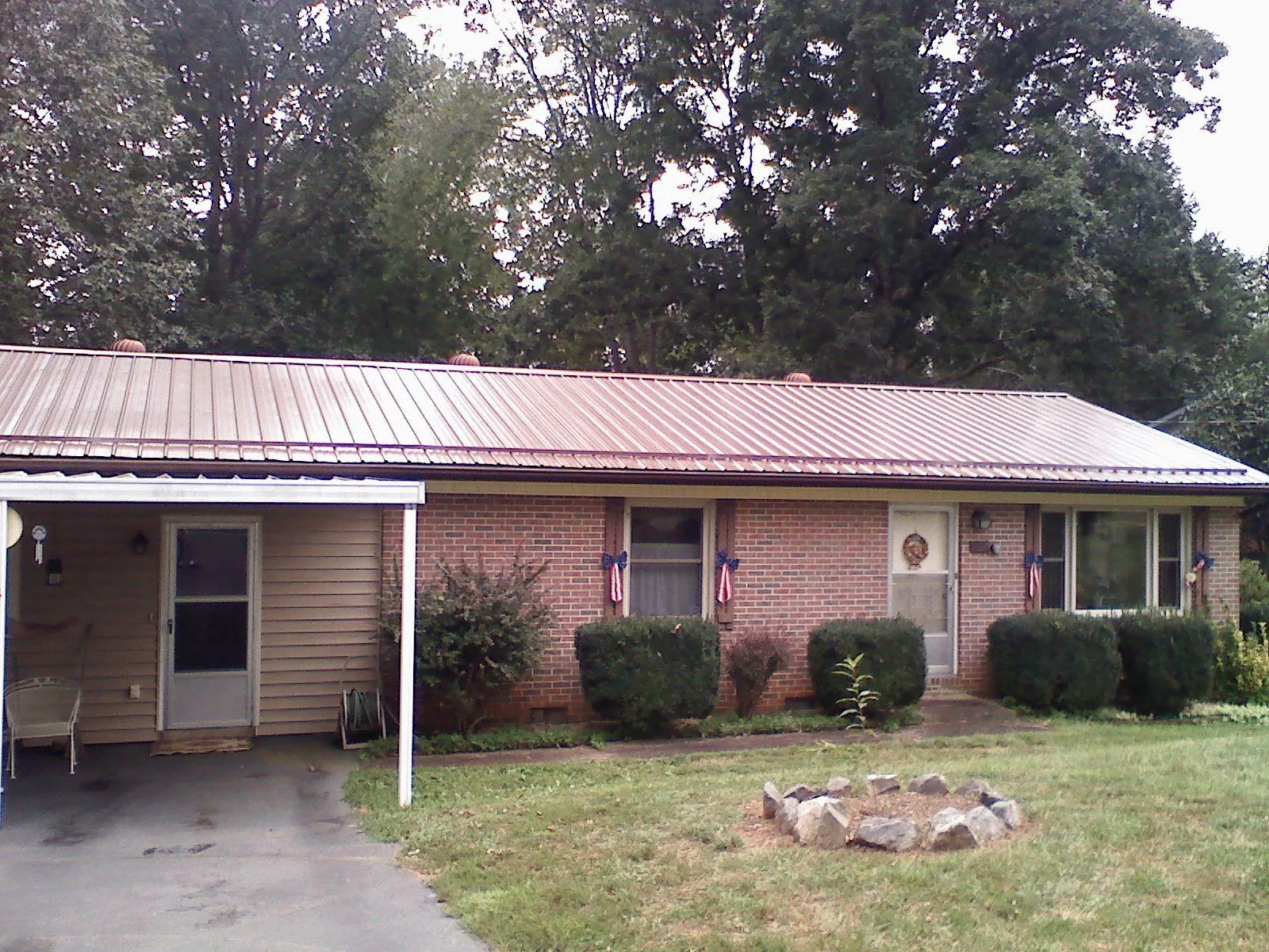 Bronze metal roof and carport on a brick ranch home — Roof Repair work by our crew in Vonore